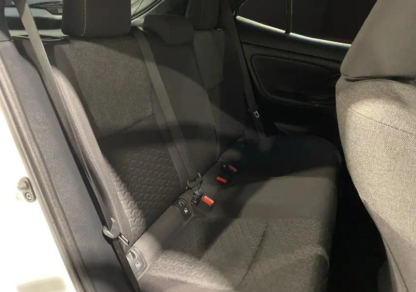 Vue côté gauche de la banquette arrière noire en tissu de la Toyota Yaris Cross 116H Design blanche.