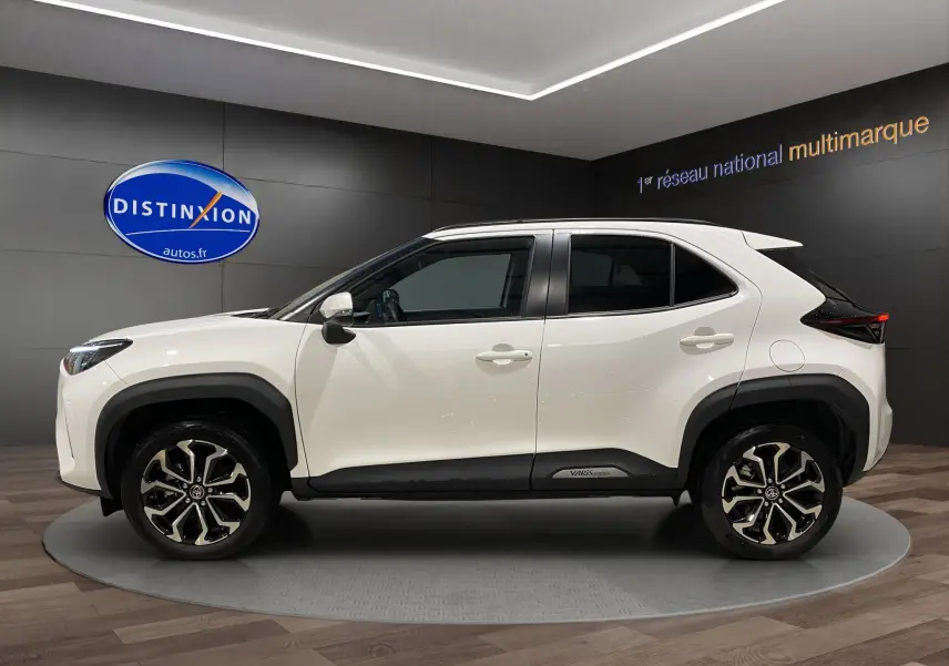 Profil droit d'une Toyota Yaris Cross blanche avec jantes alu 17 pouces et protections noires sur les passages de roues.