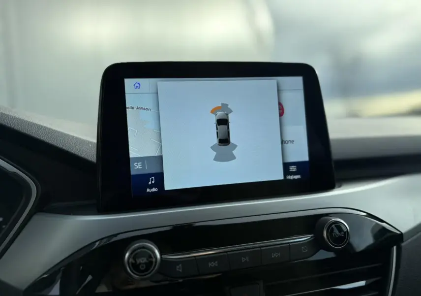 Écran tactile central du Ford Kuga 2024 affichant l'aide au stationnement, vue intérieure du tableau de bord.