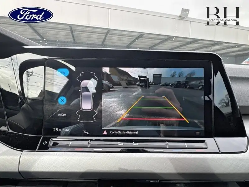 Écran tactile intérieur montrant la caméra de recul avec vue arrière et lignes de guidage colorées.