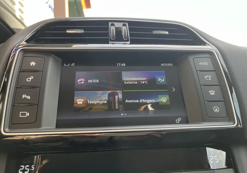 Vue rapprochée de l’écran tactile central du Jaguar F-PACE 240D Prestige 2018 avec interface climatisation et navigation.