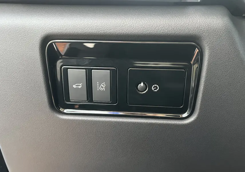 Gros plan sur les commandes noires encastrées dans la planche de bord grise du Jaguar F-PACE blanc 2018.