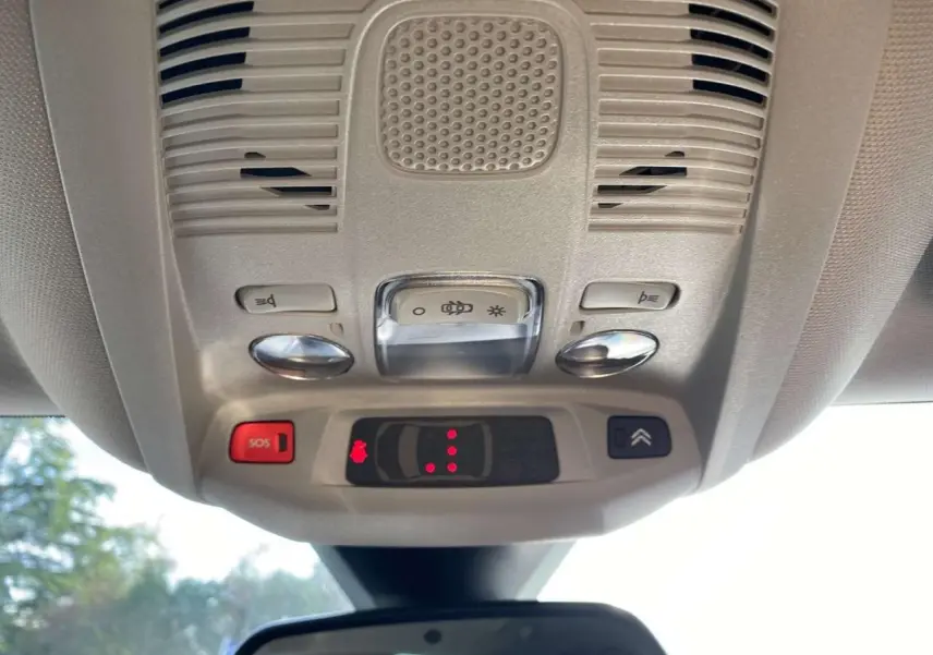 Vue en contre-plongée du plafonnier beige avec commandes d’éclairage et bouton SOS du Citroën C5 Aircross blanc.