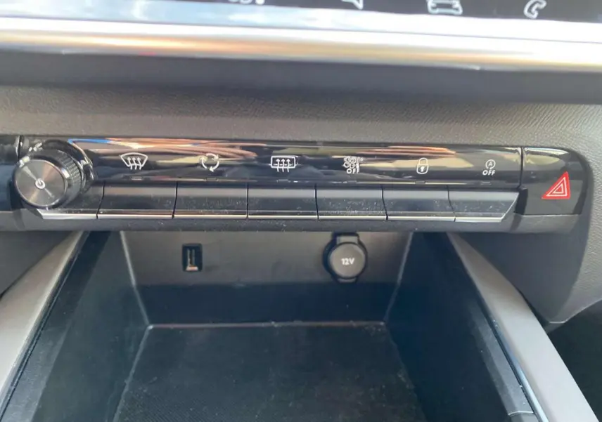 Gros plan sur la console centrale du Citroën C5 Aircross 2021, montrant les commandes de climatisation et une prise 12V.