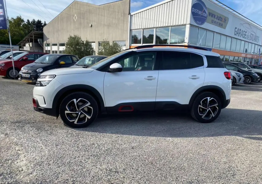 Profil côté gauche d’un Citroën C5 Aircross blanc nacré avec inserts Deep Red et jantes diamantées bi-ton.