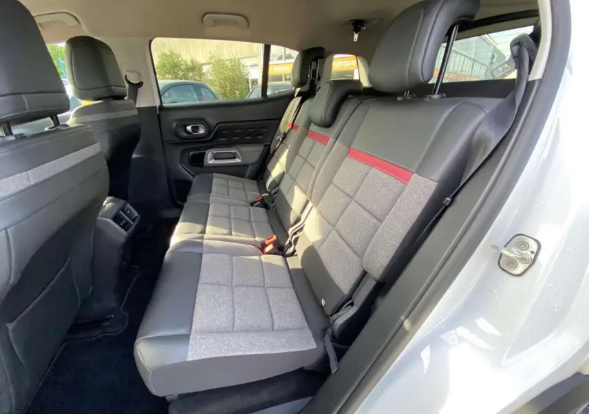Vue intérieure côté droit des sièges arrière du Citroën C5 Aircross 2021 avec sellerie cuir et tissu gris à bande rouge.