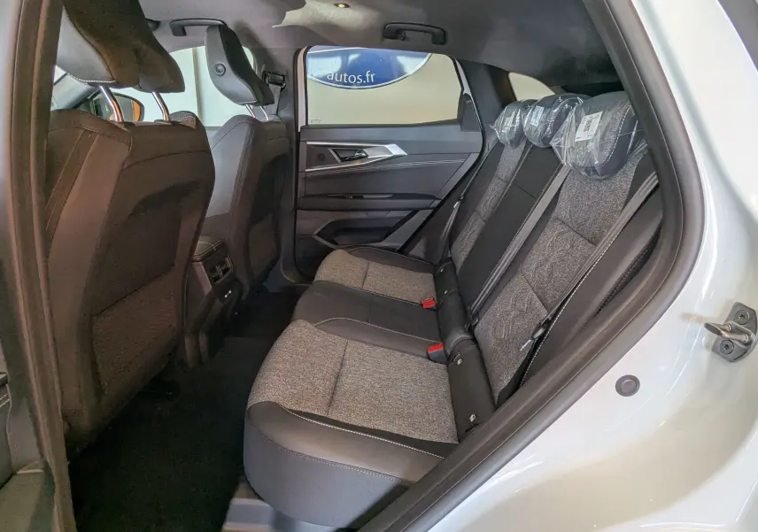 Vue intérieure côté droit sur la banquette arrière tissu gris et noir du Renault Austral E-Tech blanc nacré avec porte ouverte.