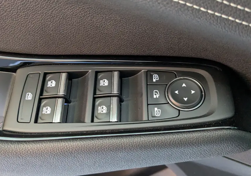 Commande des vitres électriques et réglage des rétroviseurs sur la porte côté gauche d’un Renault Austral blanc nacré.