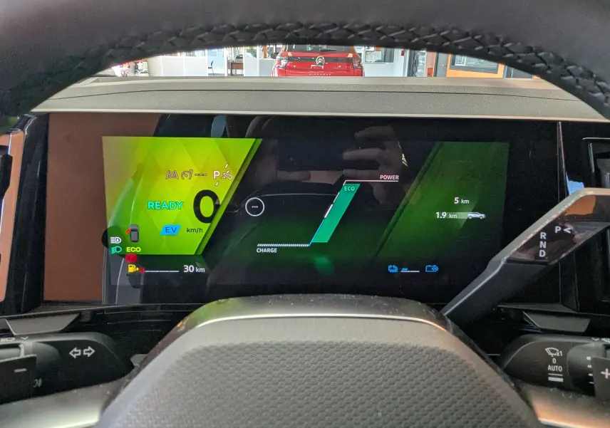 Vue intérieure du tableau de bord numérique du Renault Austral E-Tech 200 Esprit Techno avec affichage hybride et indicateurs verts.