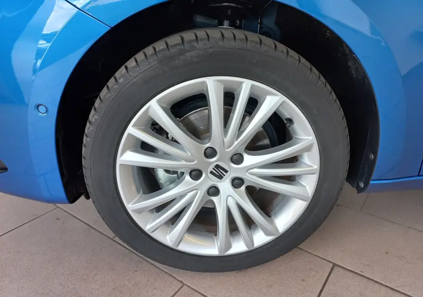 Gros plan sur la roue avant droite d’une SEAT LEON Bleu Saphir avec jante alliage multibranches.