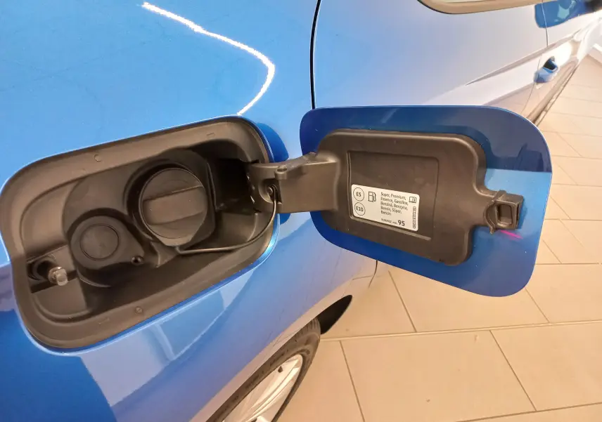 Vue rapprochée de la trappe à carburant ouverte côté gauche d’une SEAT LEON Bleu Saphir 2025 essence.