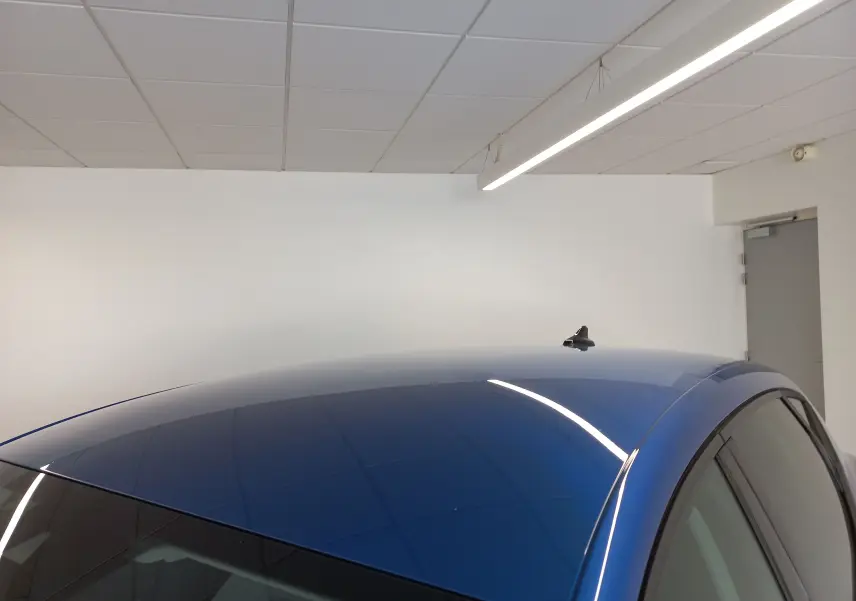 Toit bleu saphir d'une SEAT LEON 2025 avec antenne requin, vue partielle côté droit en intérieur showroom.