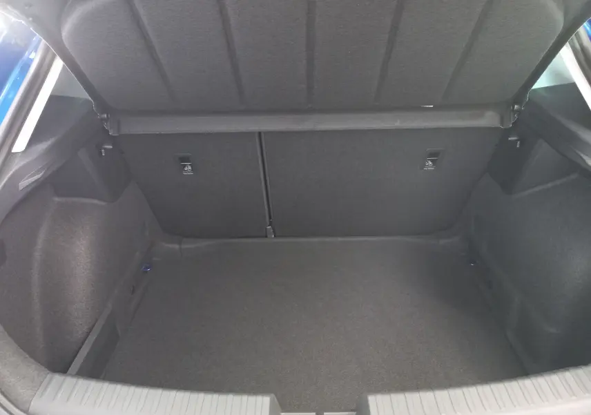 Coffre ouvert de SEAT LEON 1.5 eTSI 115 DSG7 Copa, vue intérieure, revêtement gris foncé, espace de rangement vide.