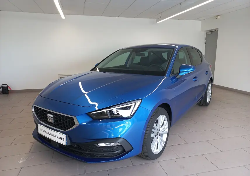 SEAT Leon 1.5 eTSI bleu saphir en 3/4 avant droit, avec calandre noire et jantes argentées visibles.