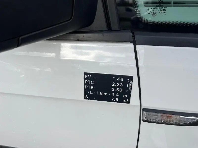 Gros plan sur l'autocollant technique noir sur la porte blanche du Volkswagen Caddy Van 2016 côté gauche.