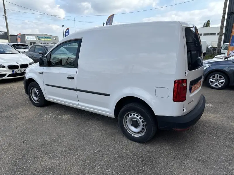 Vue 3/4 arrière droite d'un utilitaire Volkswagen Caddy Van blanc Candy avec portes arrière vitrées et jantes acier.