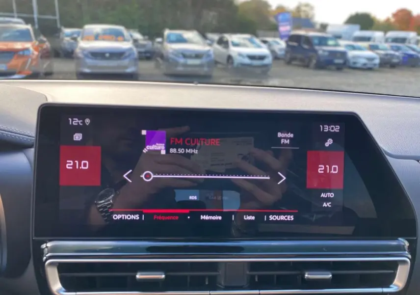 Vue du tableau de bord du Citroën C5 Aircross 2025 avec écran tactile affichant la radio FM et commandes climatisation.