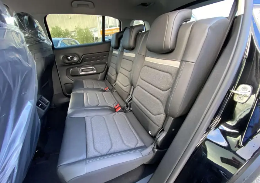 Vue latérale des sièges arrière en cuir et tissu gris du Citroën C5 Aircross noir perla avec porte ouverte côté droit.