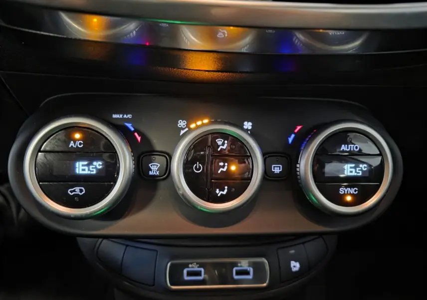 Gros plan sur la commande de climatisation automatique bi-zone de la Fiat 500X rouge, avec affichage digital à 16,5°C.
