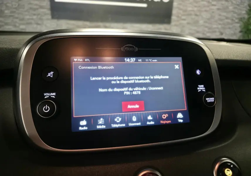 Écran tactile central du tableau de bord de la Fiat 500X 2024 affichant la connexion Bluetooth en cours.