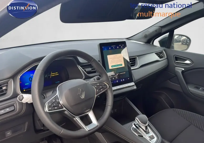 Vue intérieure côté conducteur du Renault Symbioz blanc nacré, avec tableau de bord numérique et écran tactile vertical.