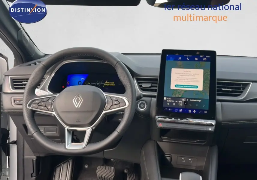 Vue intérieure centrée sur le volant et l’écran tactile vertical du Renault Symbioz blanc nacré 2025, finition Iconic.