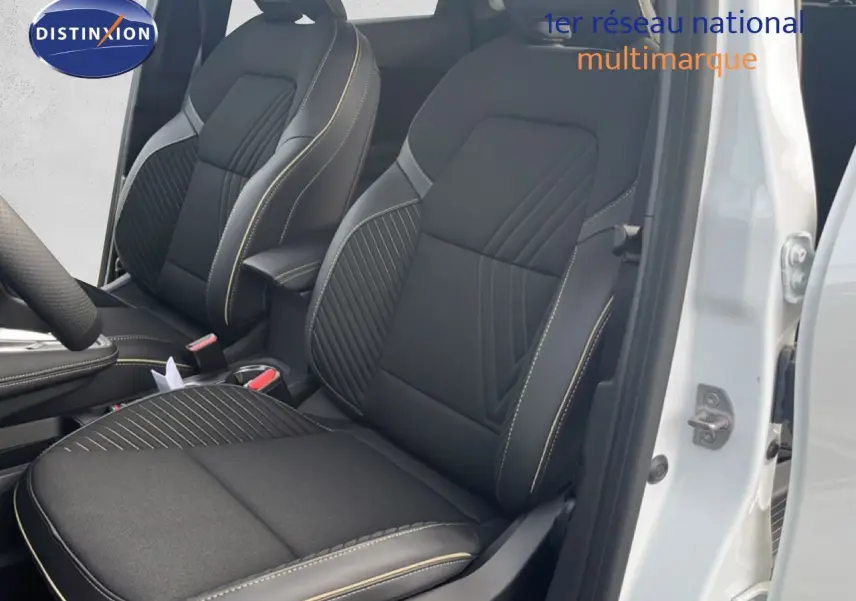 Vue intérieure sur les sièges avant noirs avec surpiqûres claires du Renault Symbioz blanc nacré 2025, porte ouverte côté droit.