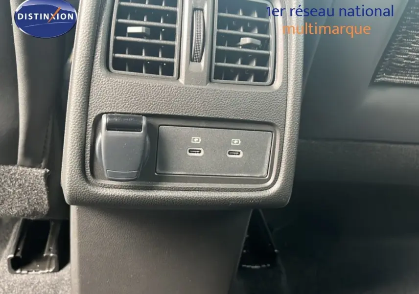 Détail des prises USB et prise 12V sous la grille d’aération arrière dans l’habitacle d’une Renault Symbioz blanc nacré.