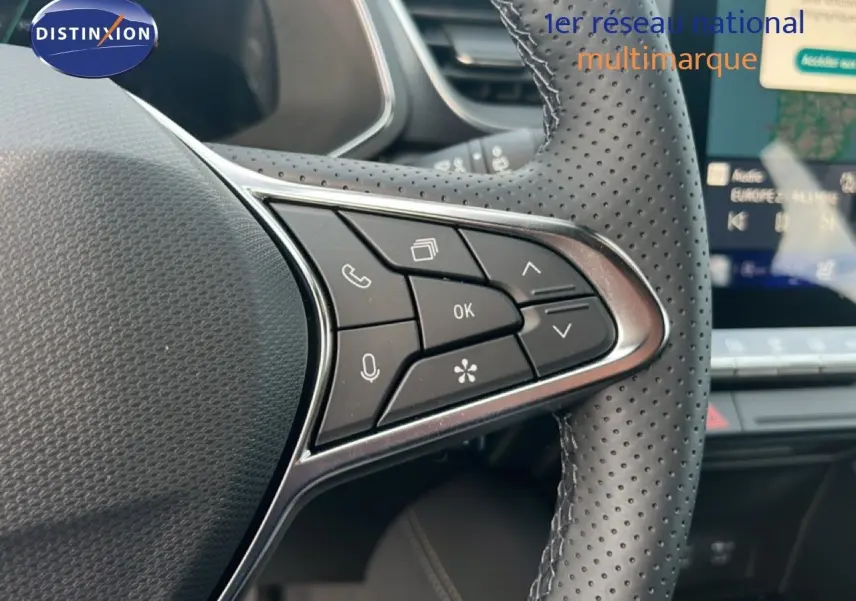 Détail du volant en cuir perforé avec commandes multifonctions, intérieur du Renault Symbioz blanc nacré 2025.