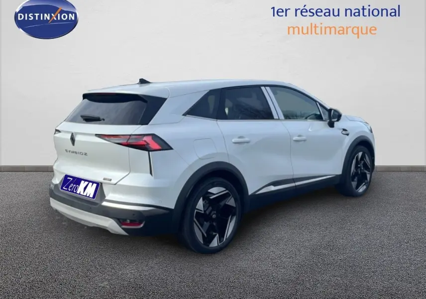Renault Symbioz blanc nacré métal vu de trois quarts arrière droit, avec jantes noires distinctives et vitres teintées.