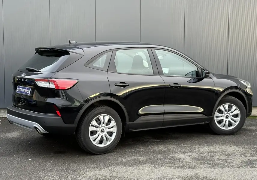 Vue de profil droit d'un Ford Kuga 2024 noir Obsidien avec attelage rétractable et jantes argentées.