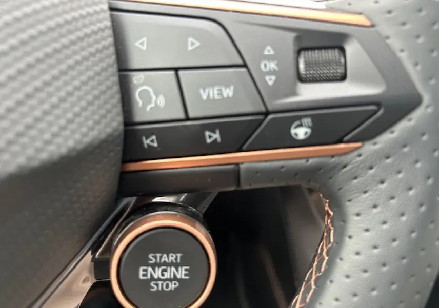 Détail du bouton Start Engine Stop et commandes sur le volant perforé avec surpiqûres cuivrées du CUPRA Formentor gris Fiord.