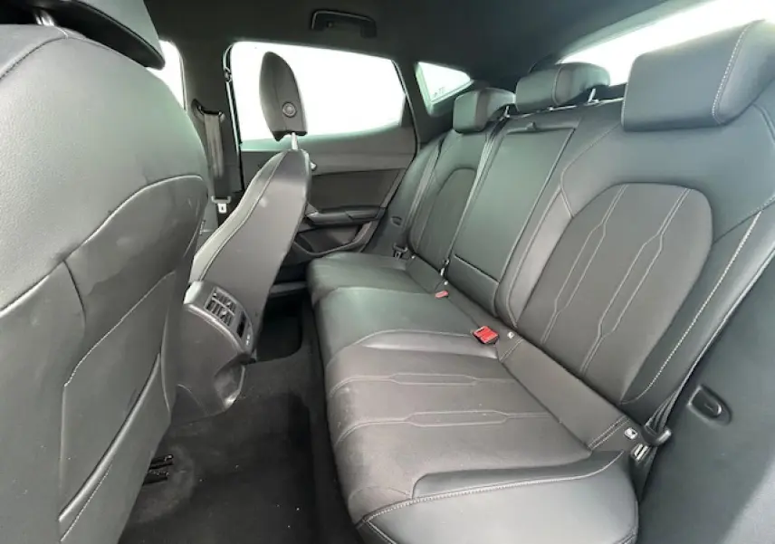 Vue intérieure côté droit des sièges arrière en cuir noir du CUPRA Formentor 2025 avec finitions sobres et appuie-têtes intégrés.