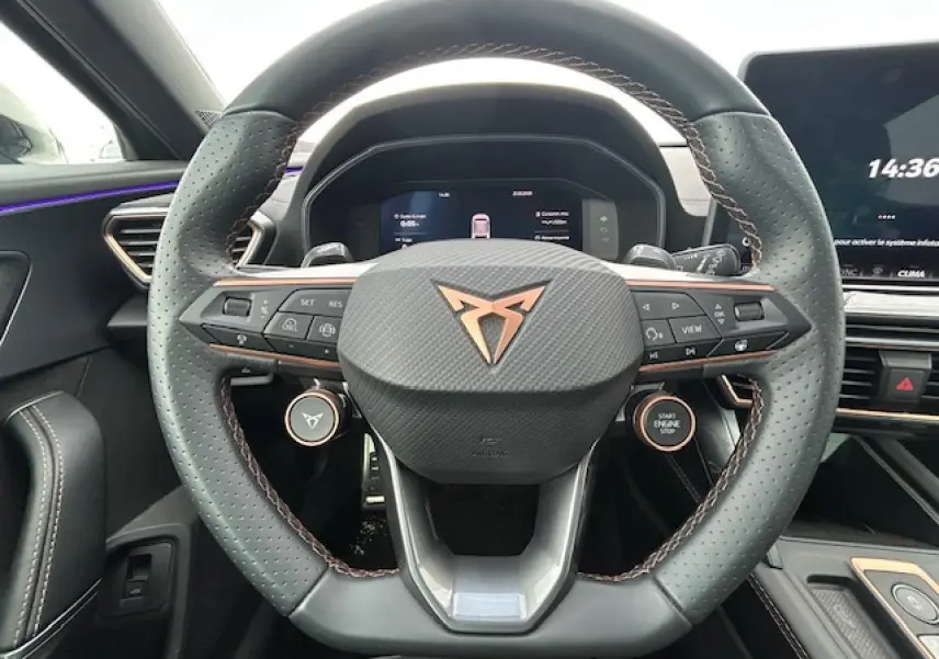 Vue rapprochée du volant cuir perforé gris avec logo CUPRA cuivre et commandes multifonctions du Formentor 2025.