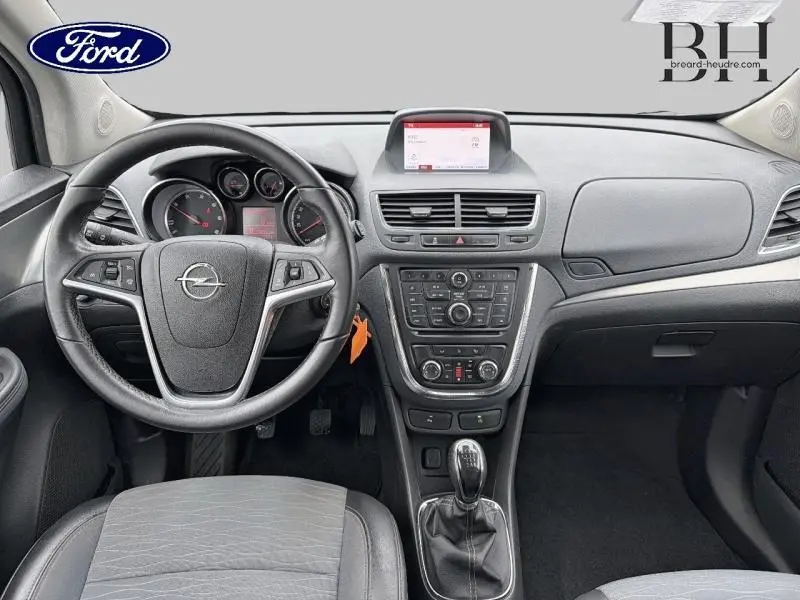 Tableau de bord et volant de l'Opel Mokka noir carbone 2016, vue avant centrée sur la console et levier manuel.