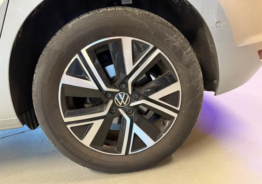 Gros plan sur la roue arrière droite gris clair du Volkswagen Touran 2.0 TDI avec jante alliage noire et argentée Alexandria.