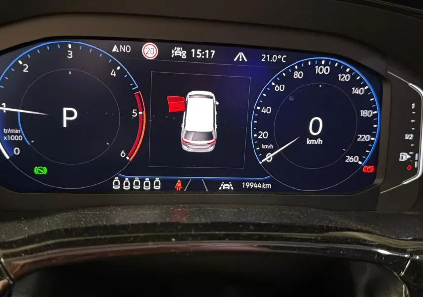 Tableau de bord numérique du Volkswagen Touran 2.0 TDI gris, affichant la vitesse à 0 km/h et porte arrière gauche ouverte.