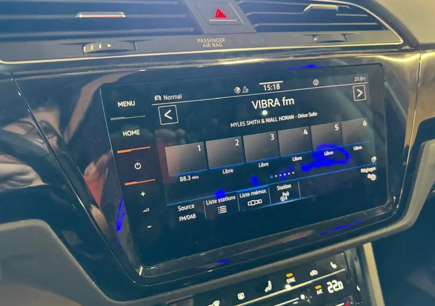 Écran tactile central du système infotainment Volkswagen Touran 2025, affichant la radio VIBRA fm en intérieur noir.