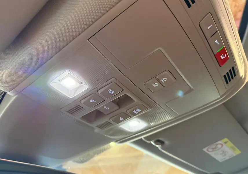 Vue intérieure en plongée du panneau de commandes de toit ouvrant et éclairage dans un Volkswagen Touran gris.