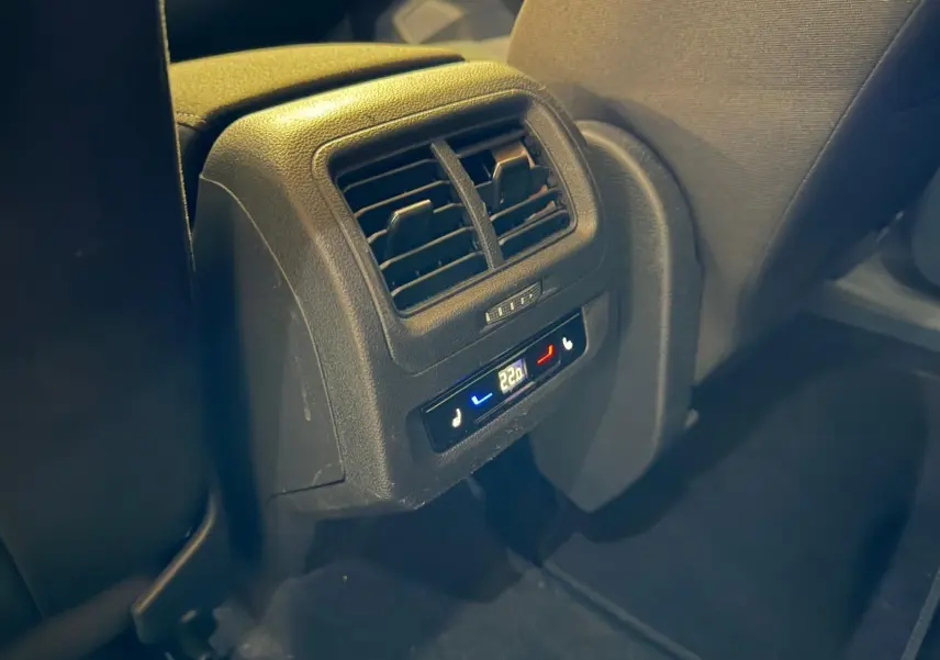 Détail de la console arrière avec commandes de climatisation et sièges chauffants dans un Volkswagen Touran gris.