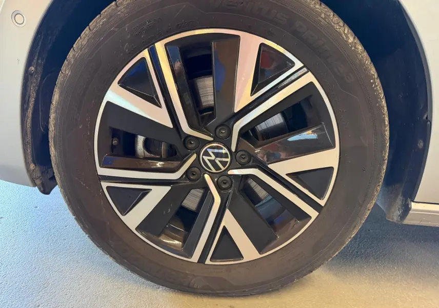 Gros plan sur la jante alliage noire et argentée « Alexandria » 17 pouces du Volkswagen Touran gris 2025 côté avant droit.