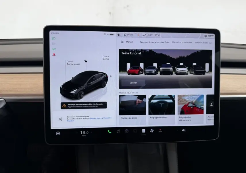 Écran tactile central affichant l'interface de contrôle d'une Tesla Model 3 noire, version Grande Autonomie, 2023.