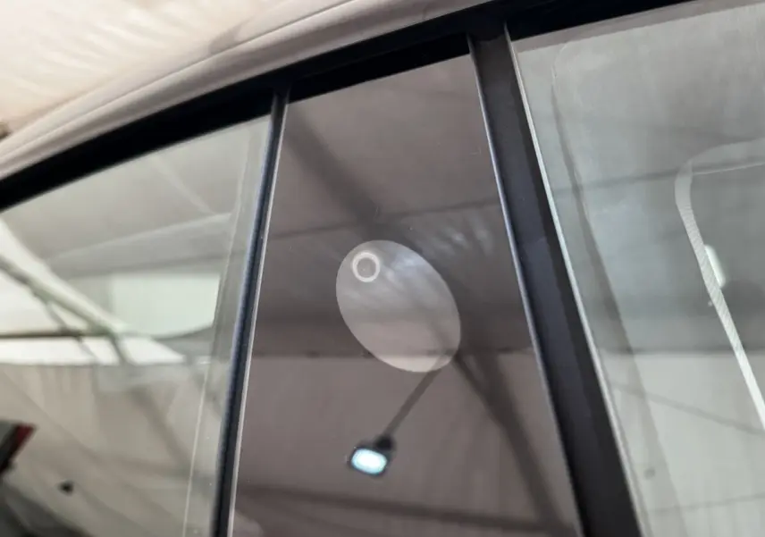Gros plan sur la caméra latérale intégrée à la vitre côté droit d'une Tesla Model 3 noire 2023 Grande Autonomie.