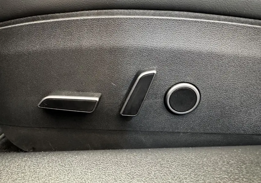 Détail des commandes électriques de réglage de siège noir dans une Tesla Model 3 Grande Autonomie 2023.