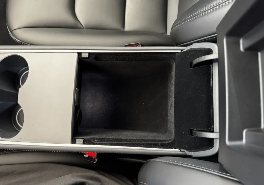 Vue plongeante sur la console centrale noire ouverte de la Tesla Model 3 Grande Autonomie 2023.