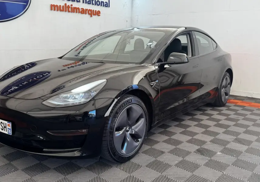Tesla Model 3 Grande Autonomie noir, vue 3/4 avant droit, jantes aérodynamiques et phares LED visibles.