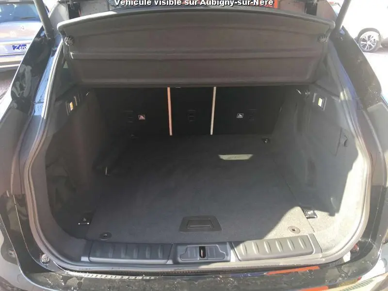 Coffre ouvert vu de l'arrière d'un Jaguar F-PACE noir, montrant un espace de chargement propre et spacieux.