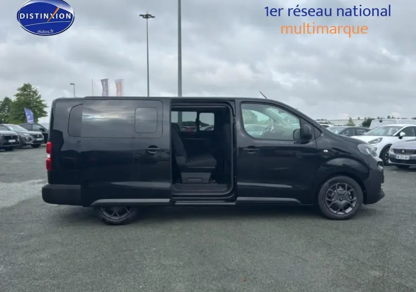 Profil droit d'un FIAT Scudo Combi noir 2026 avec porte latérale coulissante ouverte sur parking.