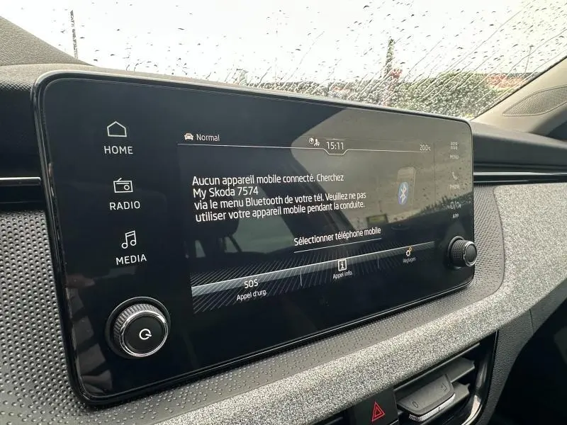 Écran tactile central de la Skoda Scala blanc cristal 2025, affichant le menu Bluetooth sous la pluie.
