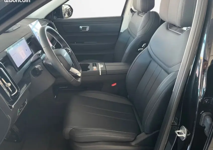 Intérieur avant côté conducteur du JAECOO J7 noir, montrant sièges cuir et tableau de bord avec écran tactile.